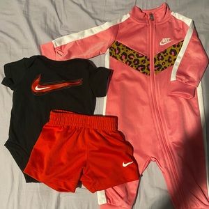 Four Nike onesies and a Nike onesie with shorts.